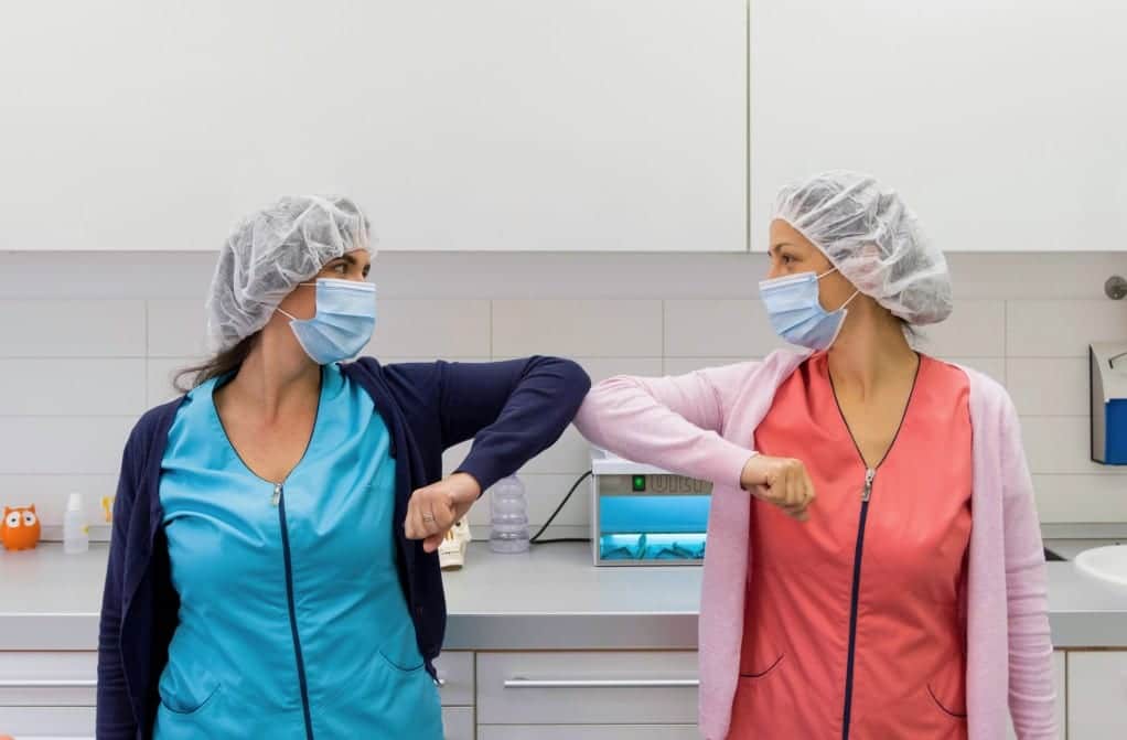 two-young-medical-workers-practicing-social-distancing-greeting-with-elbows-elbow-greeting-mask-masks_t20_WgPLaz